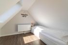  Haus am Leuchtturm Hausteil 4 Wyk auf Föhr - Im Dachgeschoss befindet sich ein Tagesbett. Aus dem Dachflächenfenster kann die Nordsee am Horizont gesehen werden.