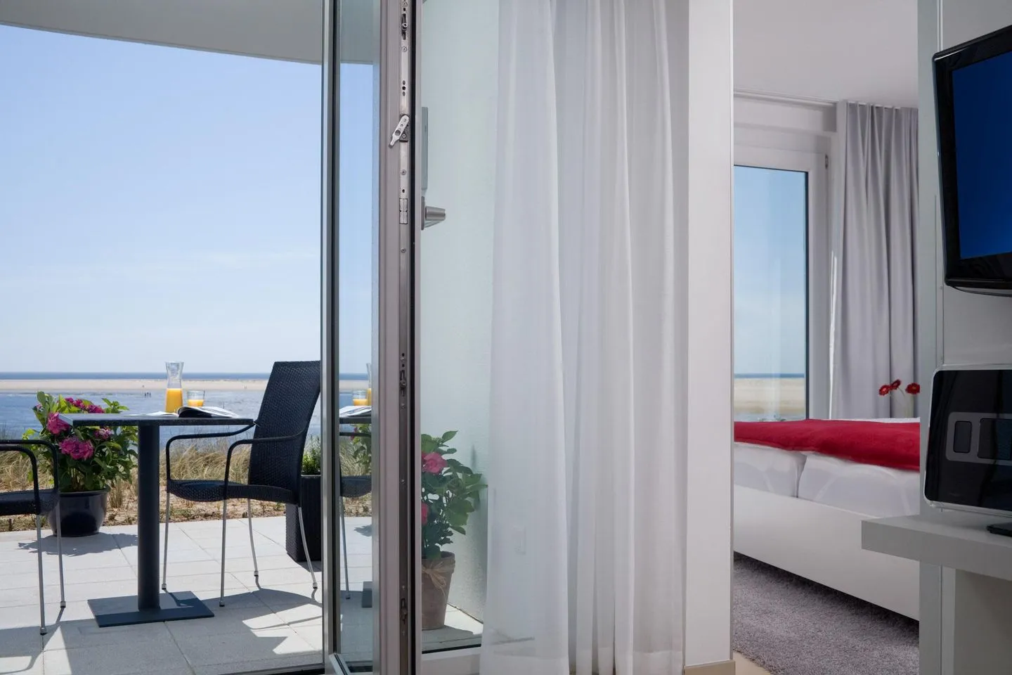 Amrumer Welle Ferienwohnung „Aalto" Wittdün auf Amrum - Terrasse und Schlafzimmer in der Ferienwohnung Aalto in Wittdün auf Amrum