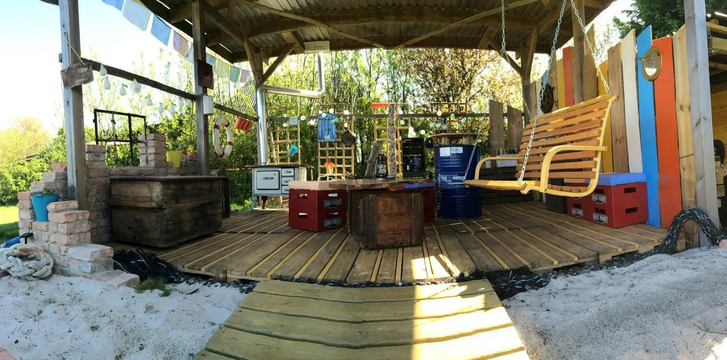 Hüs Sanskiin Ferienwohnung *Hopelfask* Süddorf auf Amrum - Hängebank in einer dekorativen Gartenlaube am Hüs Sanskiin in Süddorf auf Amrum