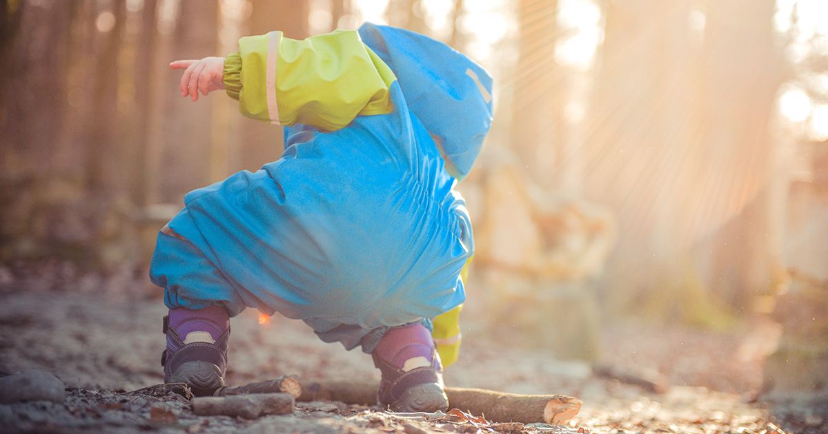 Kind spielt im Winter im Wald