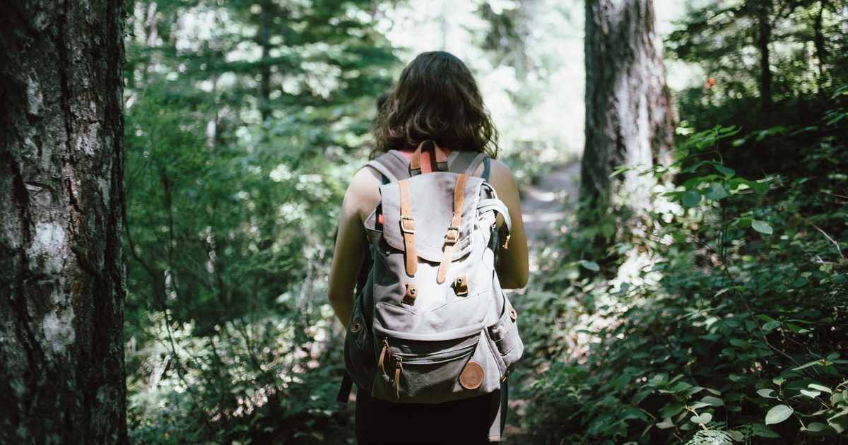 Frau wandert allein im Wald