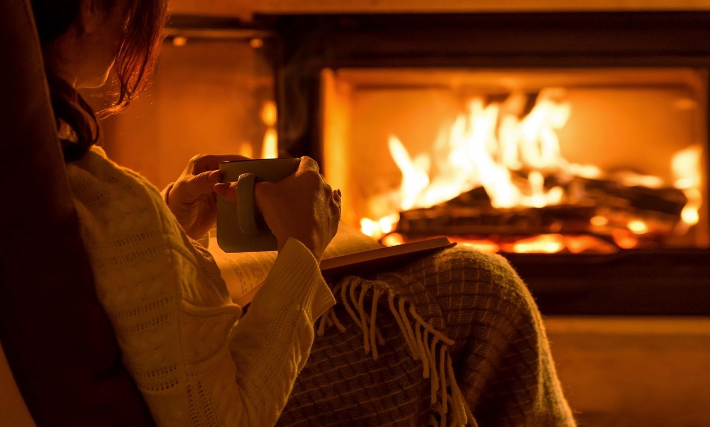 Frau mit Teetasse am Kamin