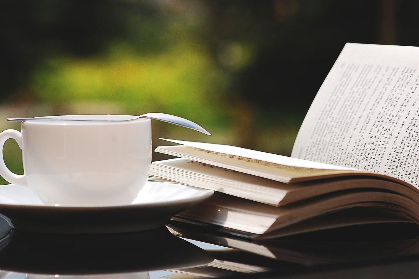 Tasse Kaffe neben aufgeschlagenem Buch