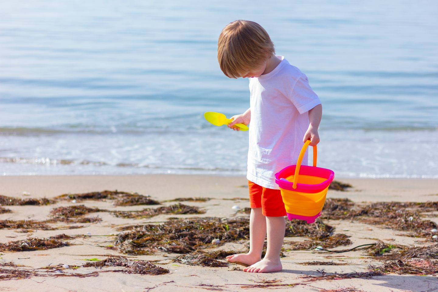 Kind am Strand mit Eimer und Schaufel