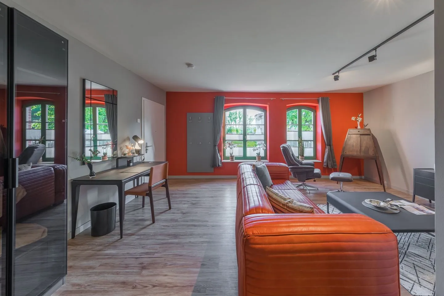 Schwalbenblick Klink - Ferienwohnung Schwalbenblick rote Couch und Schreibtisch
