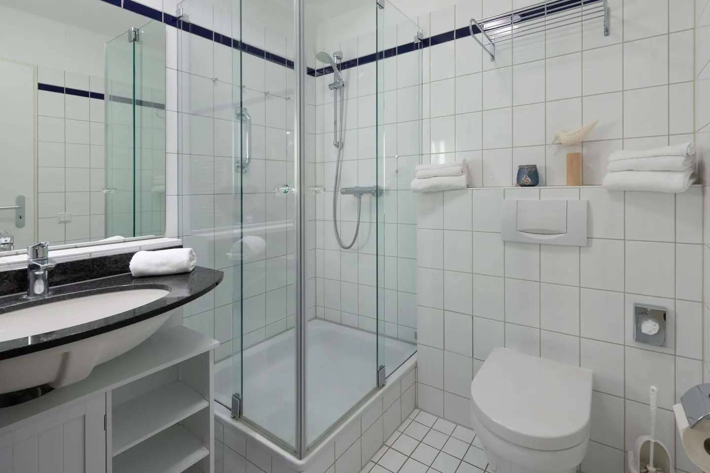 Godewind Zingst - Ferienwohnung Godewind Blick ins Badezimmer mit Glasdusche, Waschbecken und Toilette