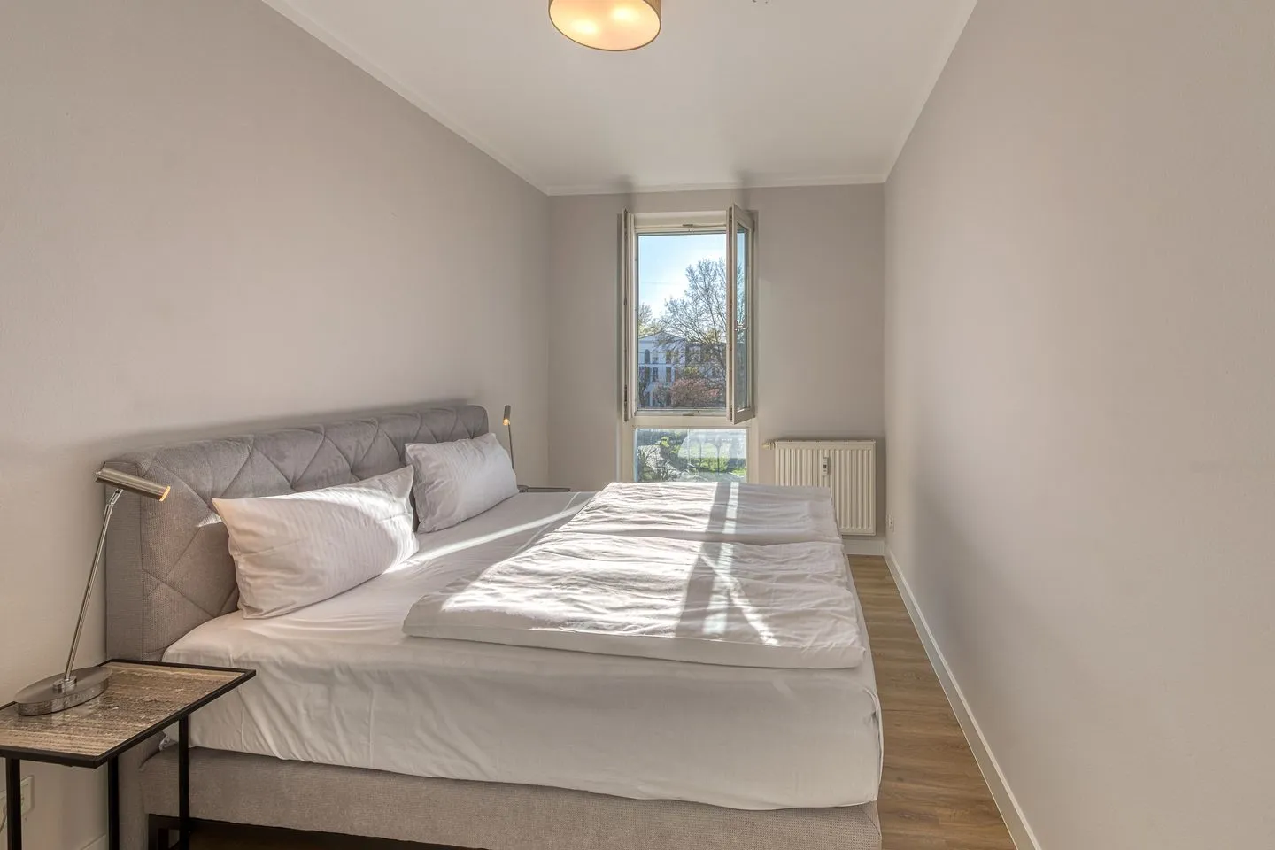 Windflüchter Zingst - Ferienwohnung Windflüchter Blick ins helle Schlafzimmer mit Doppelbett und Fenster