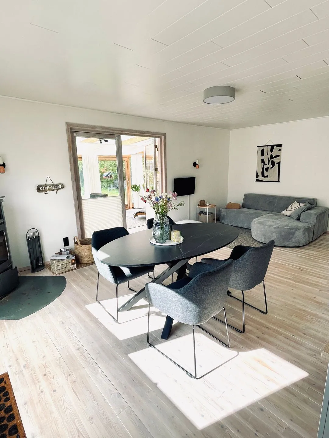 VITA Sonnholm Flensburger Förde - Wohnbereich mit Sofa, TV, Ofen und Zugang zum Wintergarten