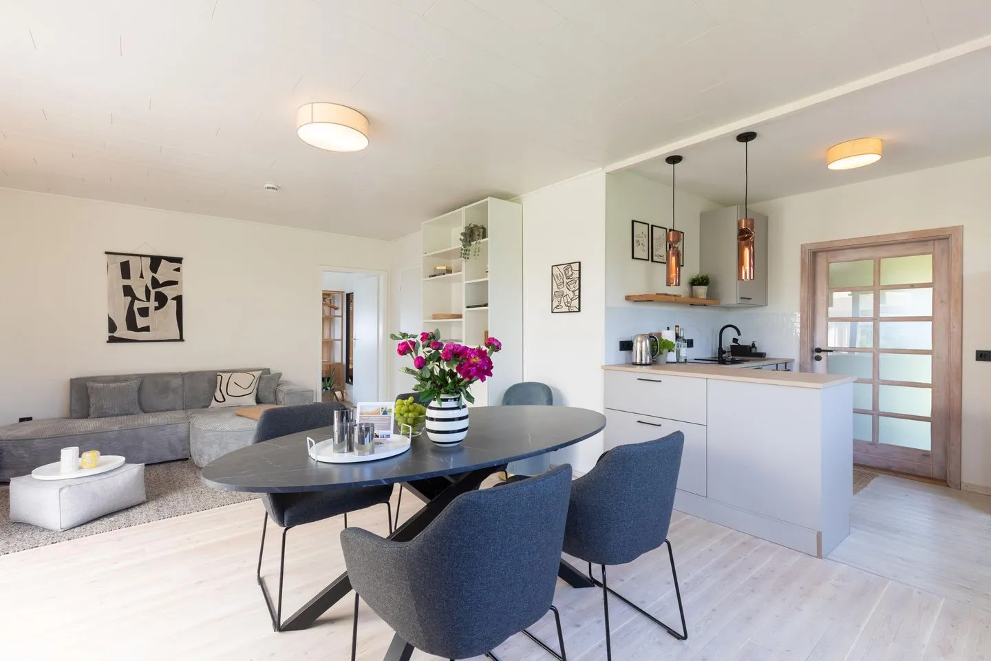 VITA Sonnholm Flensburger Förde - Wohnzimmer mit TV-Ecke, Esstisch und Küchenzeile
