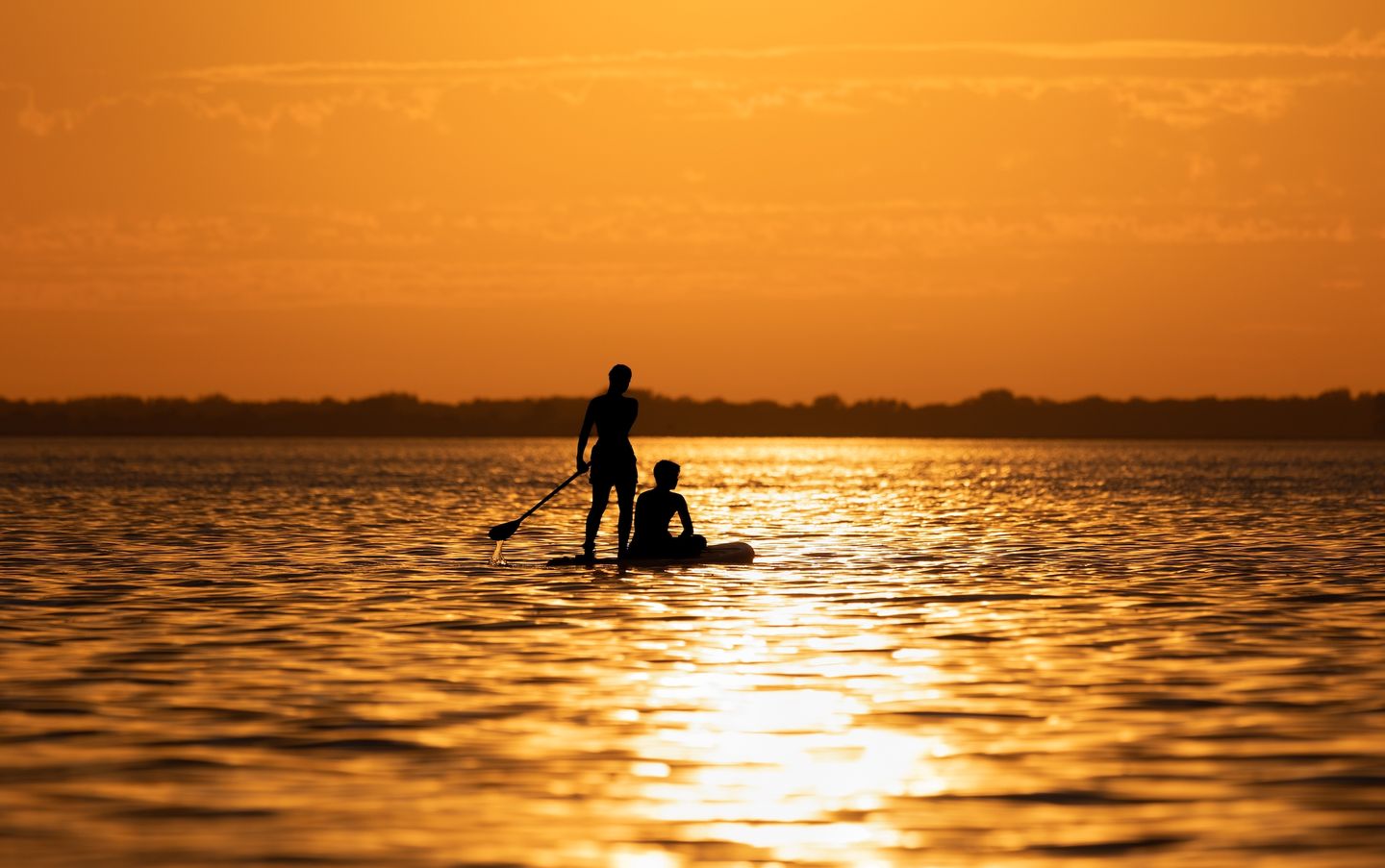 Stand up paddling bei Sonnenuntergang