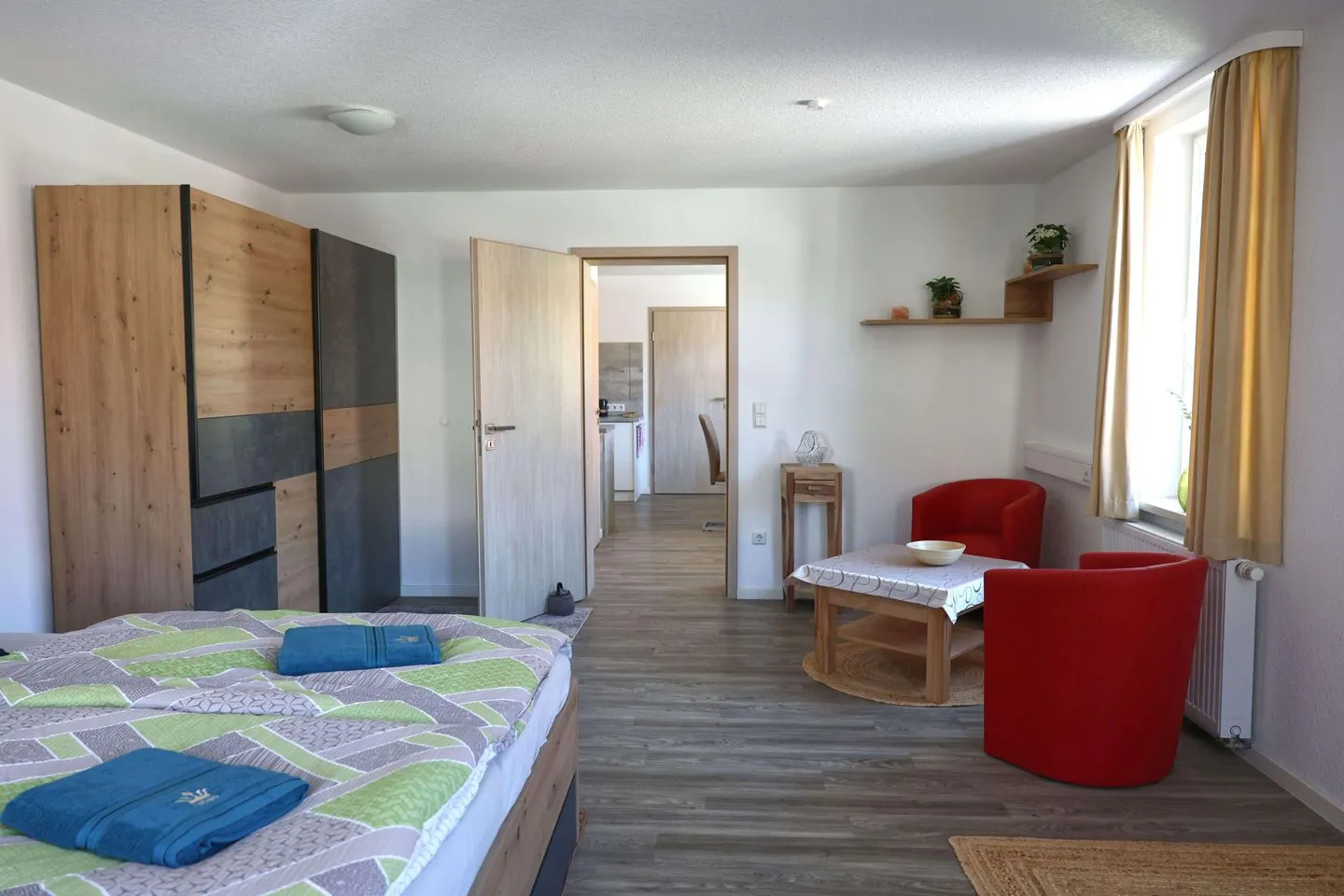 Ferienwohnung Zur Sonne Thüringer Wald - Schlafzimmer mit Sitzecke und Blick in Richtung Esszimmer