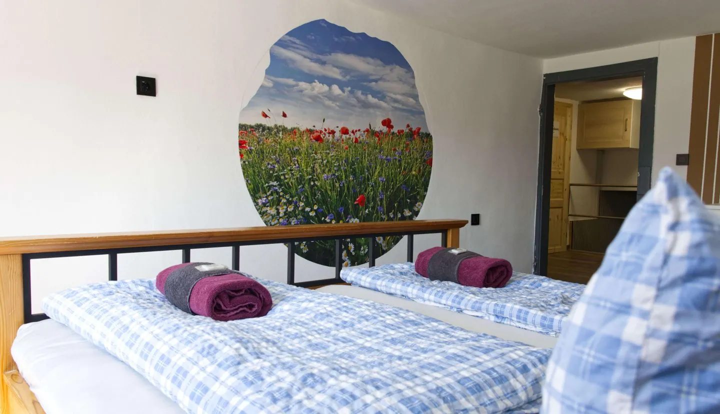 Ferienapartment Zur guten Quelle Thüringer Wald - 2. Schlafzimmer ab der 3. Person verfügbar - Blick über das Bett mit dekorativen Wandbild