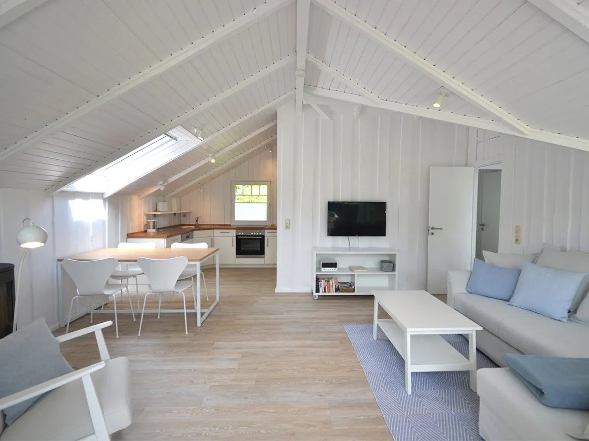 Lille Hus Flensburger Förde - Wohnzimmer mit TV, Ofen und offener Küche