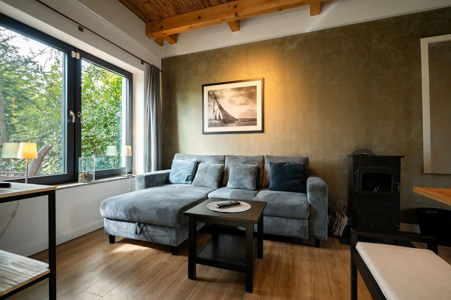 Große Sommerliebe Waren (Müritz) - Ferienhaus Große Sommerliebe Waren (Müritz) - Gemütliches Wohnzimmer mit moderner Couch und großem Fenster