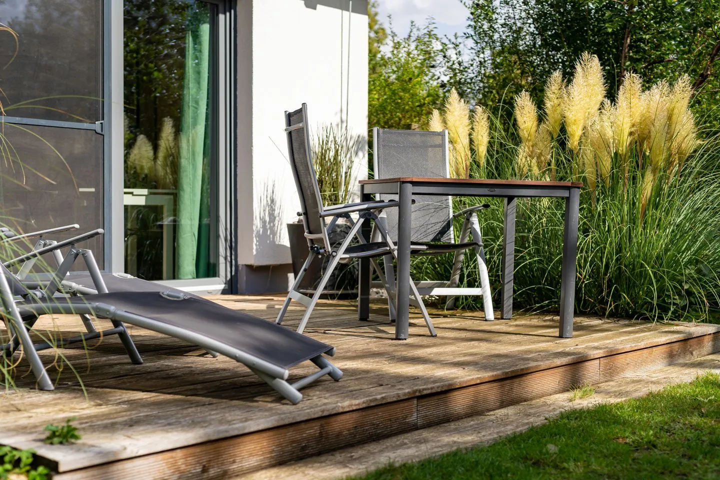 Kleine Sommerliebe Waren (Müritz) - Ferienhaus Kleine Sommerliebe Waren (Müritz) - Gemütliche Außenterrasse mit Liegestuhl und Gartentisch