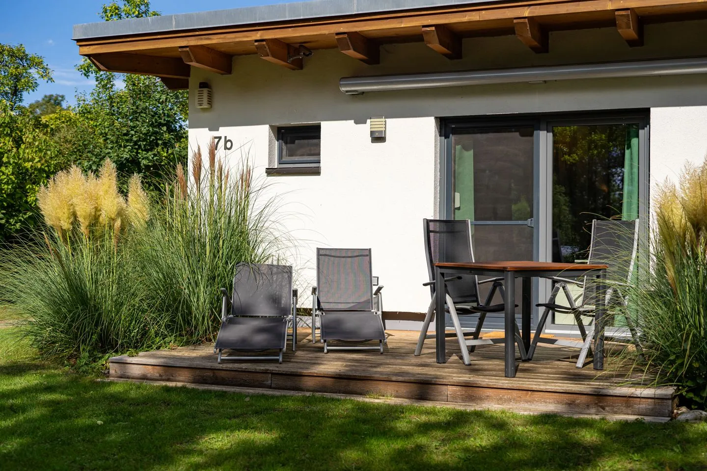 Kleine Sommerliebe Waren (Müritz) - Ferienhaus Kleine Sommerliebe Waren (Müritz) - Sonnige Holzterrasse mit Gartenmöbeln und Liegen