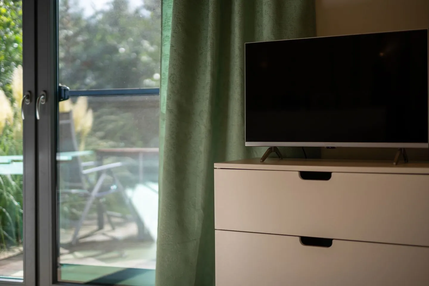 Kleine Sommerliebe Waren (Müritz) - Ferienhaus Kleine Sommerliebe Waren (Müritz) - TV-Bereich mit Kommode und Blick auf die Terrasse