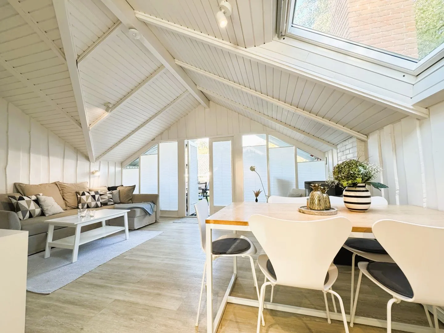 Lille Hus Flensburger Förde - Wohnbereich mit Essplatz, Couchecke, Kamin und TV