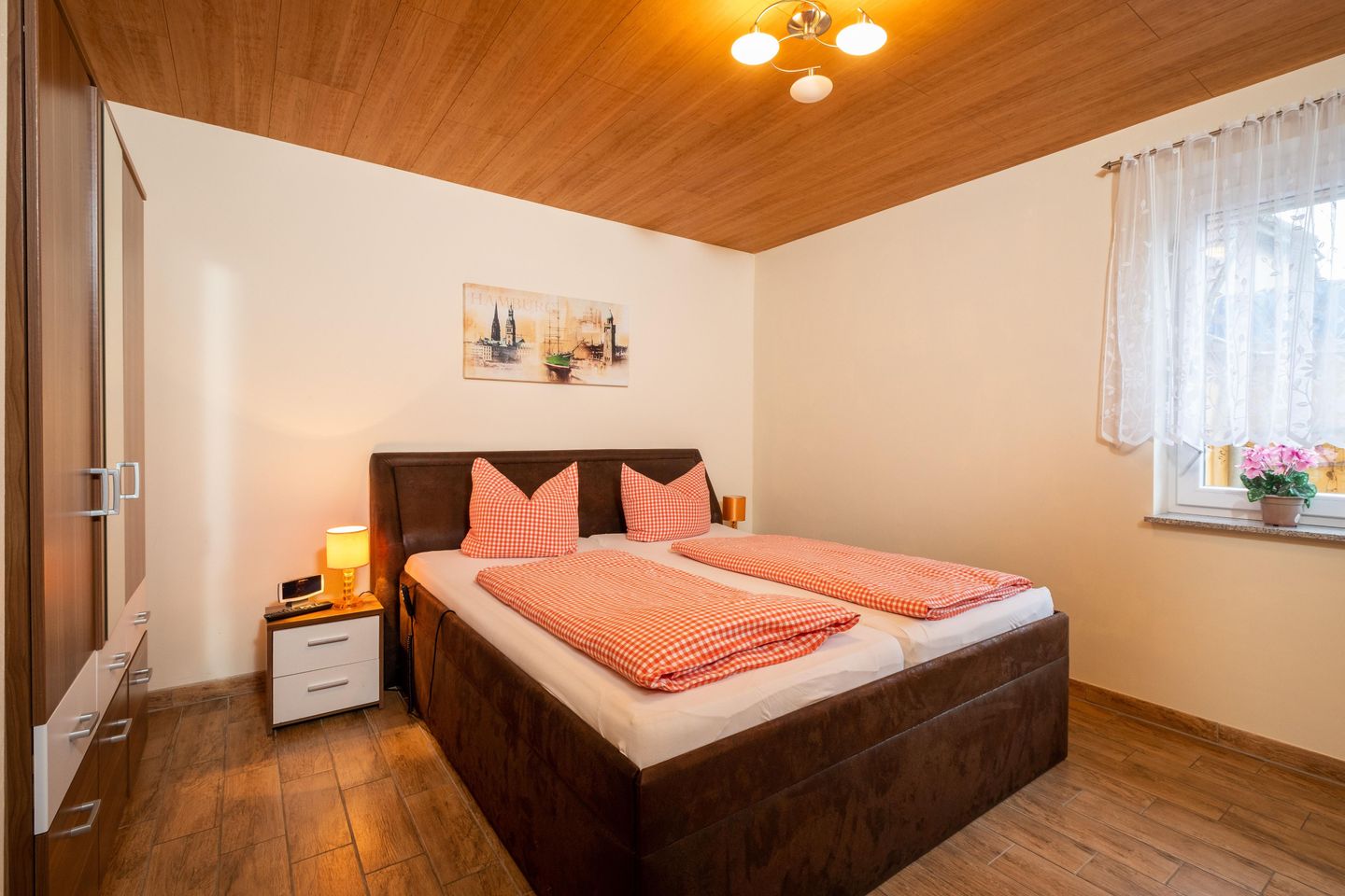 Schlafzimmer mit TV und Komfortbett, die motorisch in Kopf- und Fußteil verstellbar ist.