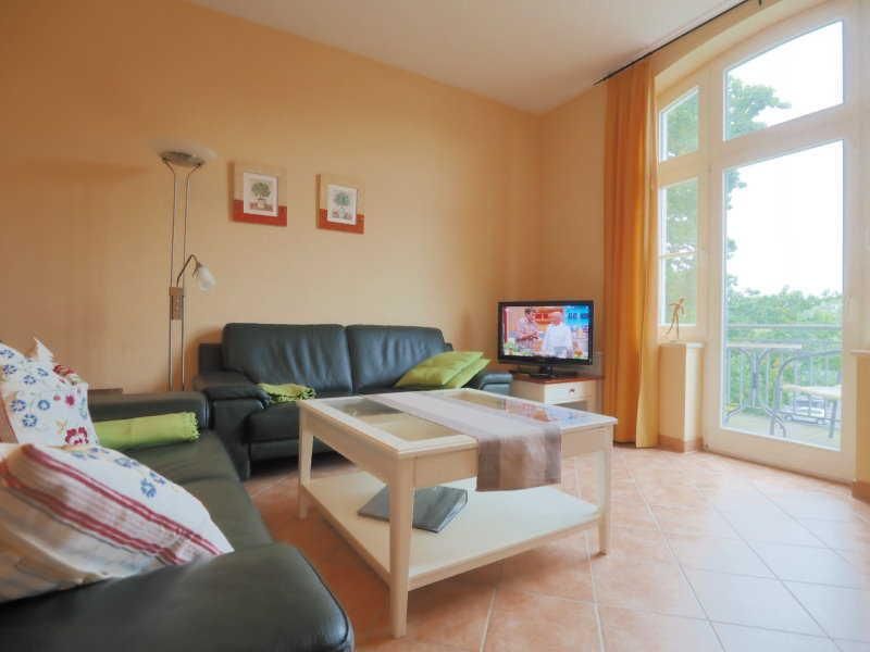 Wohnbereich mit Flachbildfernseher und Zugang zum Balkon