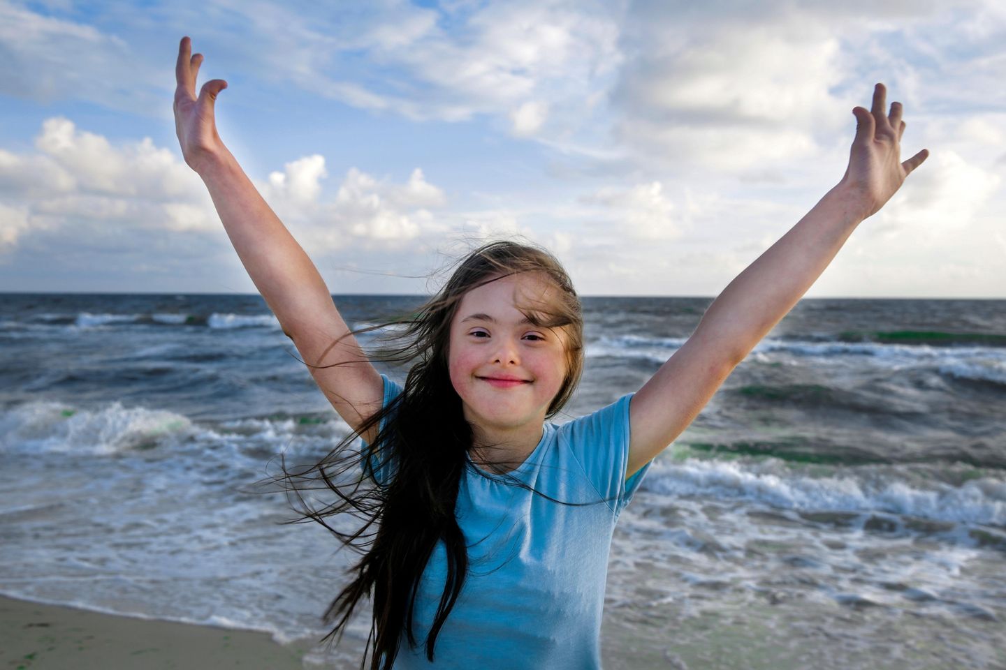 Fröhliches Kind mit Down Syndrom am Strand von Amrum