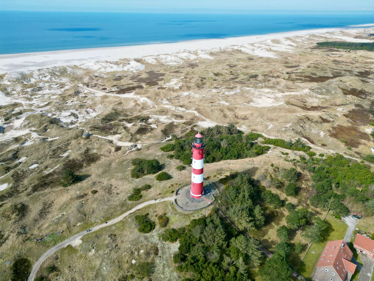 Der Leuchtturm der Nordseeinsel Amrum aus der Luft fotografiert.Dünen und die Nordsee im Hintergrund