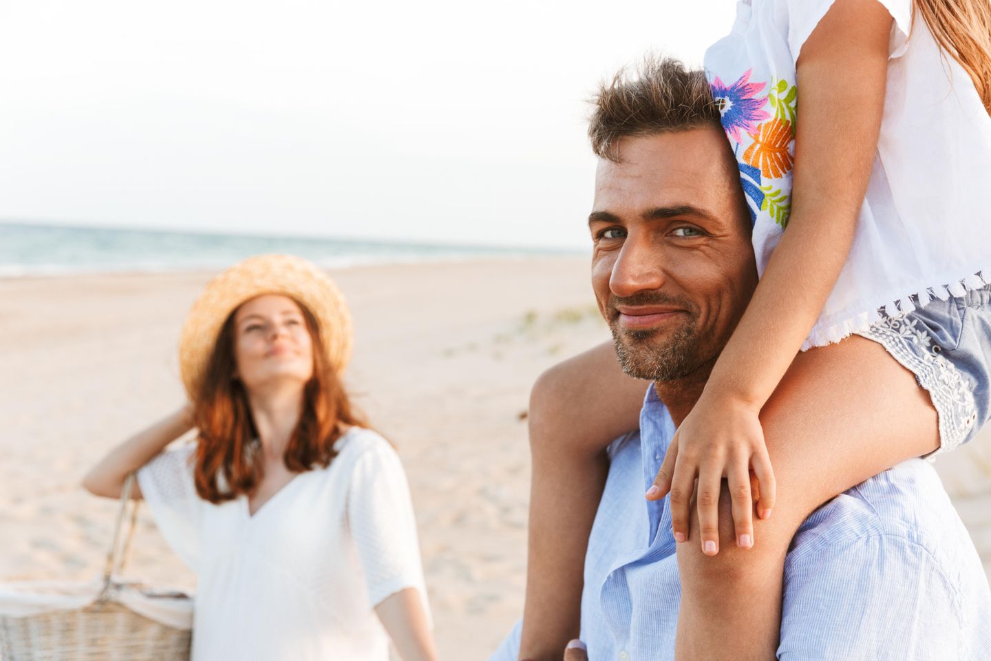 Familie am Strand von Nebel auf Amrum, Tochter sitzt auf den Schultern des Vaters, alle sind glücklich