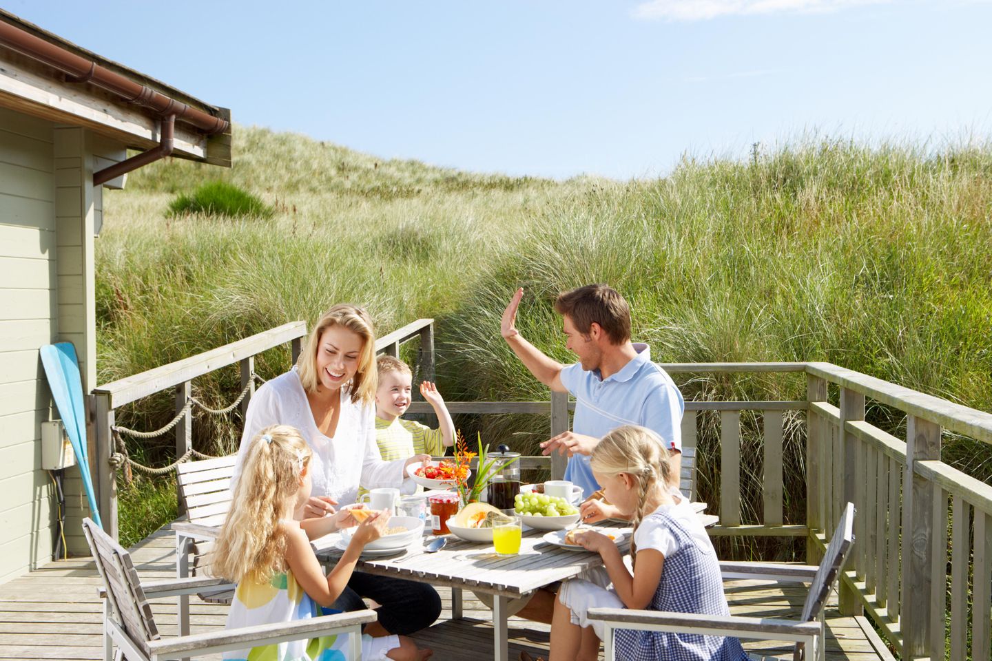 Familie beim Frühstück auf einer Terrasse in den Dünen von Norddorf auf Amrum