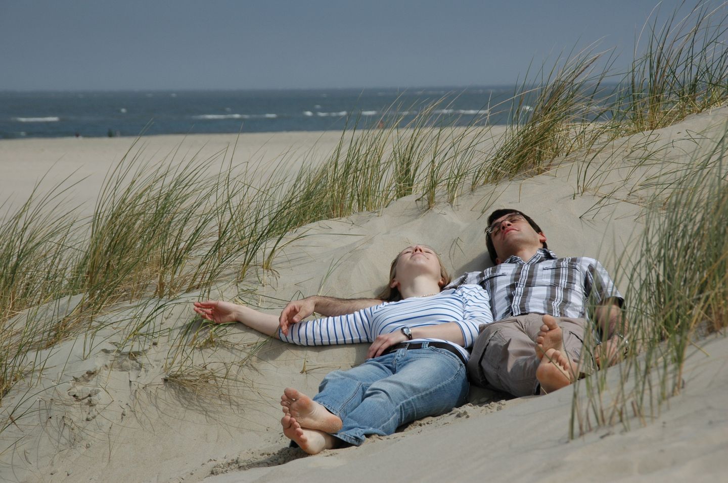 Paar im Dünensand vor dem Kniepsand auf Amrum