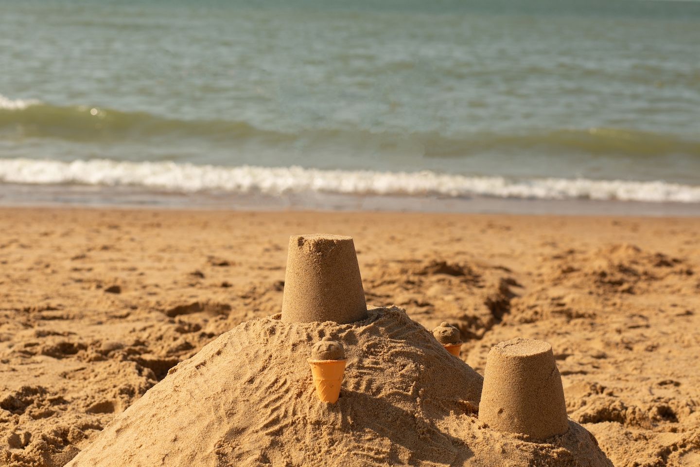 Strandburg mit Eisform am Strand, ruhige Ostsee im Hintergrund