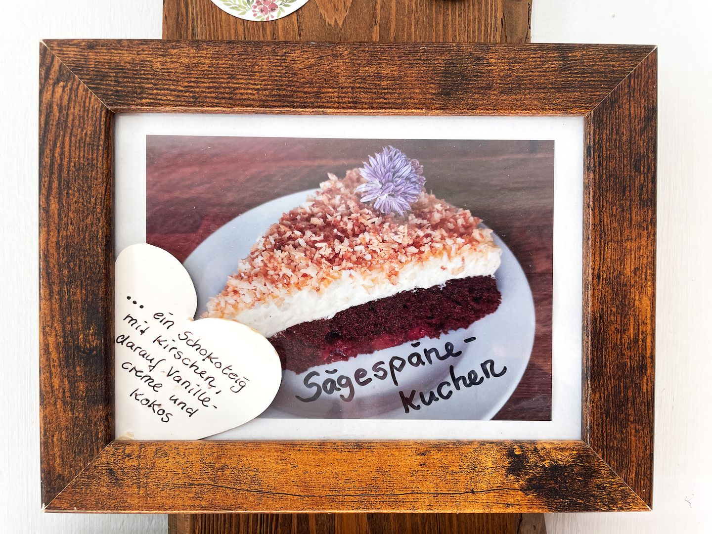 Teller mit Sägespänekuchen aus Schokoboden mit Kirschen, Pudding topping und gerösteten Kokosraspeln