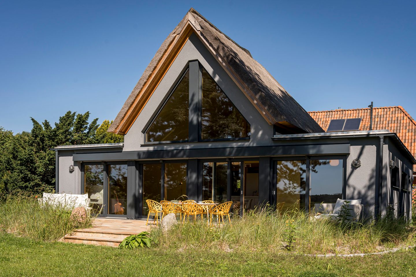 Ferienhaus Offenblick in Wieck am Darß, Blick vom Garten auf das Haus mit Terrasse davor