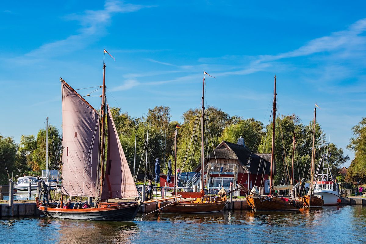 traditionelle Zeesbote mit roten Segeln im Hafen von Ahrenshoop