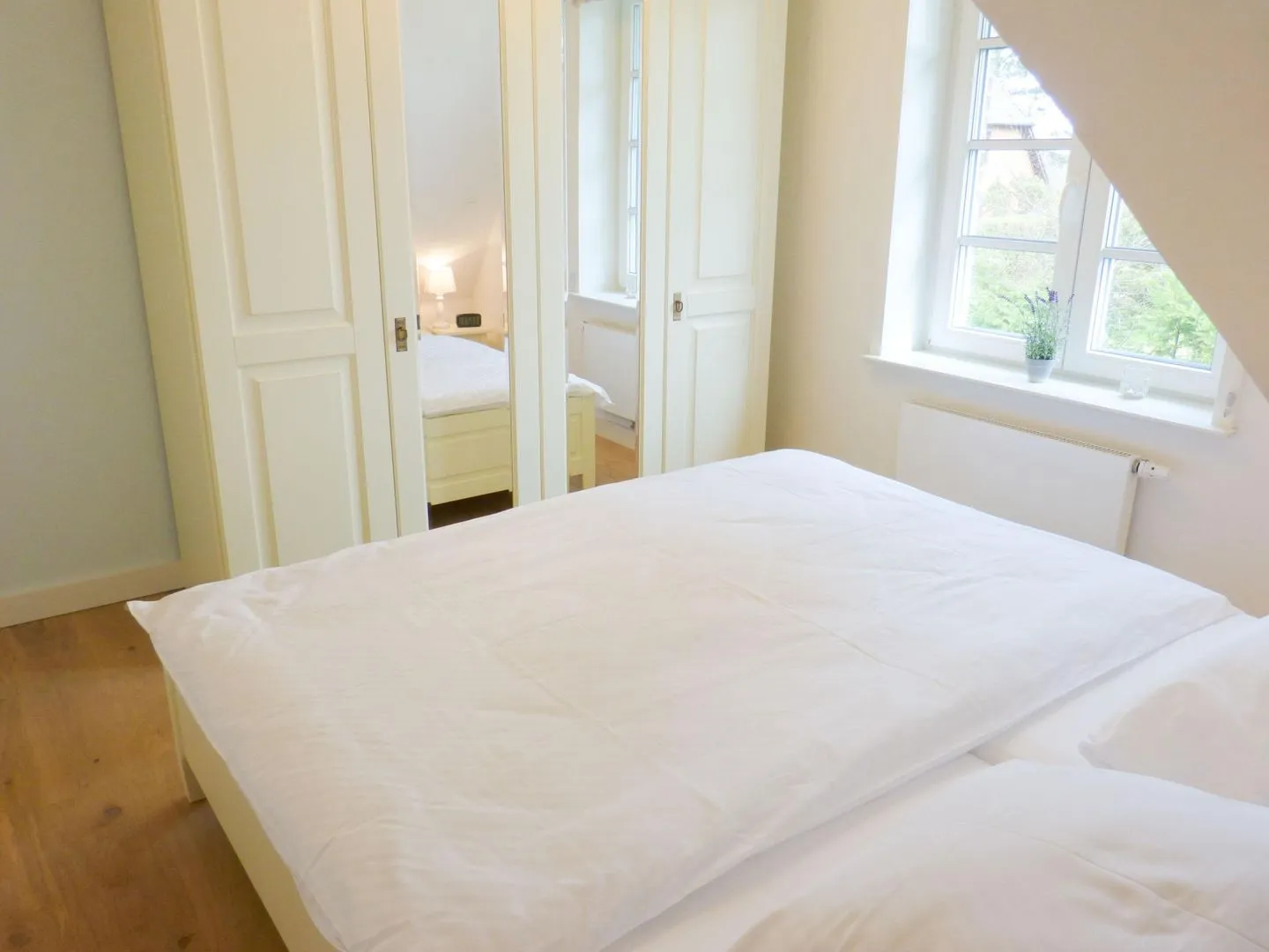 Heidehüs Friesenhaushälfte *Seepferdchen* Süddorf auf Amrum - Schlafzimmer mit Blick in den Garten in der Ferienwohnung Seepferdchen in Süddorf auf Amrum